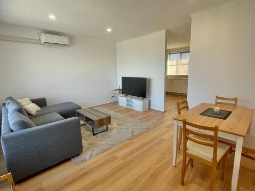 a living room with a couch and a table at Central Apartment near Dandenong Hospital & Market in Dandenong