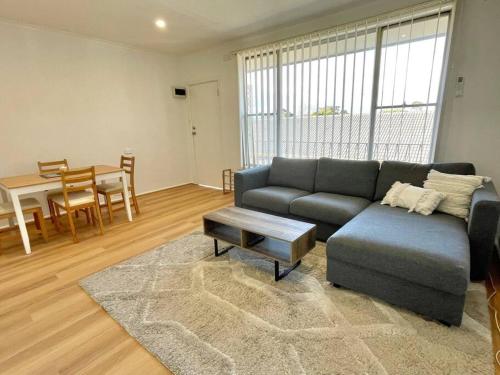 a living room with a couch and a table at Central Apartment near Dandenong Hospital & Market in Dandenong