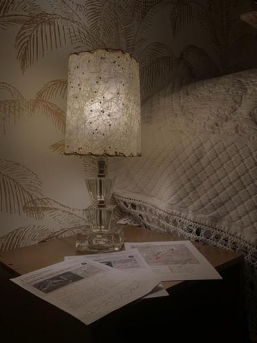 a lamp sitting on a table next to a bed at Appartement centre Apt Bèlavista luberon in Apt
