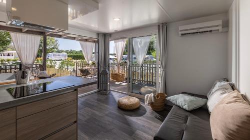 a caravan kitchen with a couch and a balcony at Polidor Camping Resort in Poreč