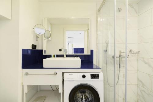 uma máquina de lavar roupa na casa de banho com um espelho em Orbi City Superhost em Batumi