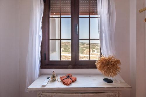 a window with a cat sitting on a wooden bench at La Casa del Abuelo in Zuheros