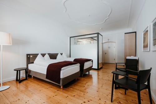 ein Schlafzimmer mit einem großen Bett und einem Stuhl in der Unterkunft Hotel Kloster Fischingen in Fischingen