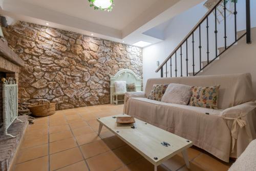a living room with a couch and a stone wall at La Casa del Abuelo in Zuheros
