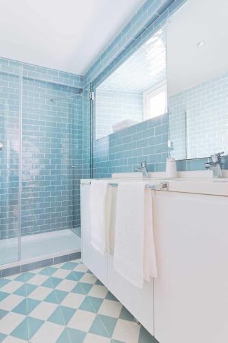 a bathroom with blue tiles and white towels at Downtown Charming Apartments - Apartamento Castelo in Chaves