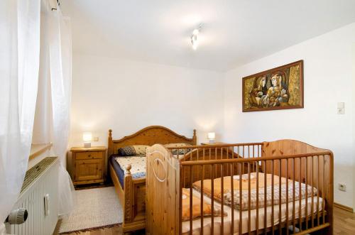 ein Schlafzimmer mit einem Kinderbett und einem Bett in einem Zimmer in der Unterkunft Ferienwohnung Auszeit in Salem