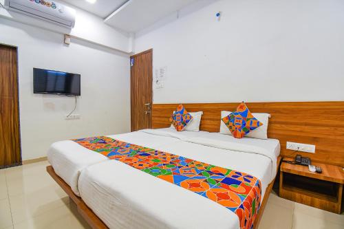 a bedroom with a large bed and a television at FabHotel The Address in Nashik