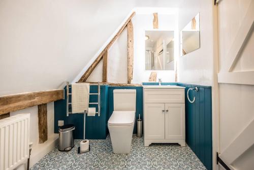 a bathroom with a toilet and a sink at The Hayloft Valley Farm Barns Snape Air Manage Suffolk in Saxmundham