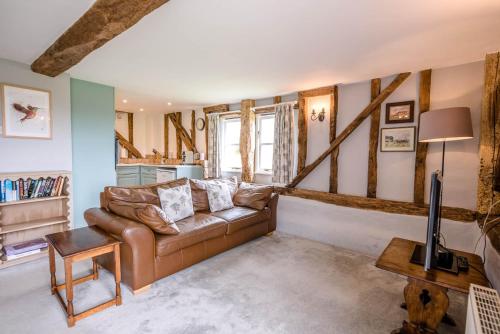 a living room with a couch and a table at The Hayloft Valley Farm Barns Snape Air Manage Suffolk in Saxmundham