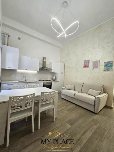een keuken en een woonkamer met een tafel en een bank bij My Place Apartments in Policoro