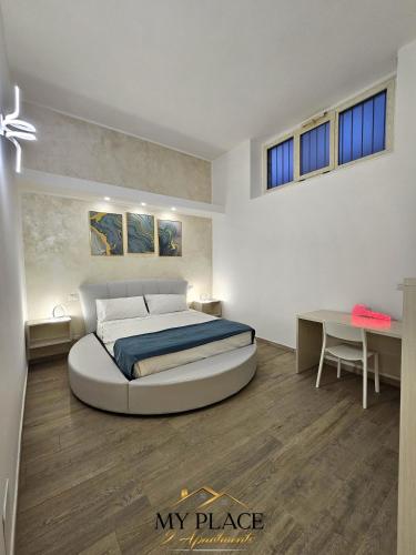 een slaapkamer met een groot bed en een bureau bij My Place Apartments in Policoro