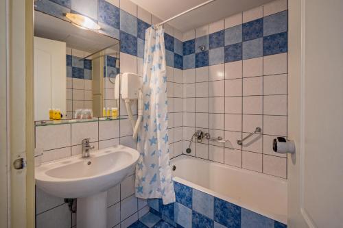een badkamer met een wastafel en een bad bij Lefkoniko Complex-Beach and Bay in Rethimnon