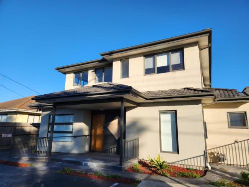 a white house with a black roof at Maruve Guesthouse 12 min from Melb airport in Melbourne