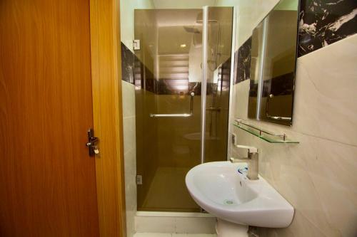 a bathroom with a sink and a shower at Oasis Villa Lekki in Lekki