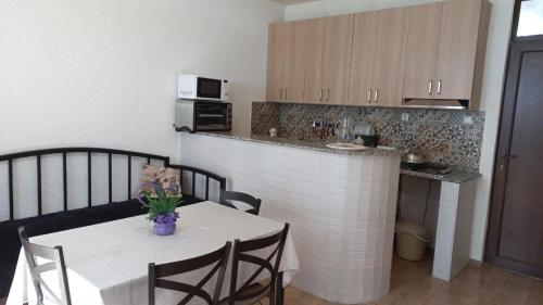 una cocina con una mesa y sillas blancas y una encimera. en Leto by Sveta, en Ureki
