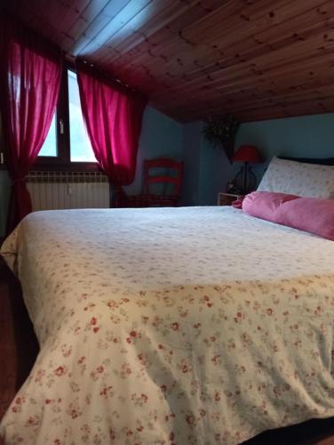 ein Schlafzimmer mit einem großen Bett mit rosa Vorhängen in der Unterkunft Adamello in Aprica