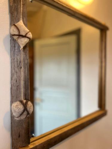 a mirror with a wooden pole and a door at Slow Travel Mývatn - Óli's Homestay-Private house v in Myvatn