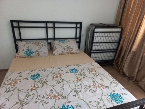 a bed with a floral bedspread and pillows on it at Leto by Sveta in Ureki