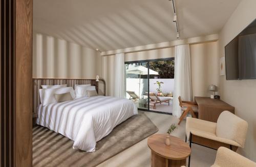 Anfitrión Villas & Suites في مربلة: غرفة نوم مع سرير وغرفة معيشة