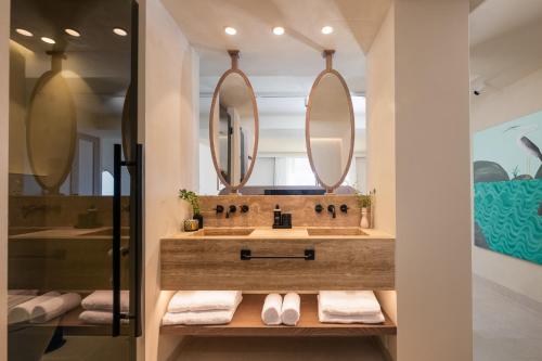 マルベーリャにあるAnfitrión Villas & Suitesのバスルーム(洗面台、鏡2つ付)