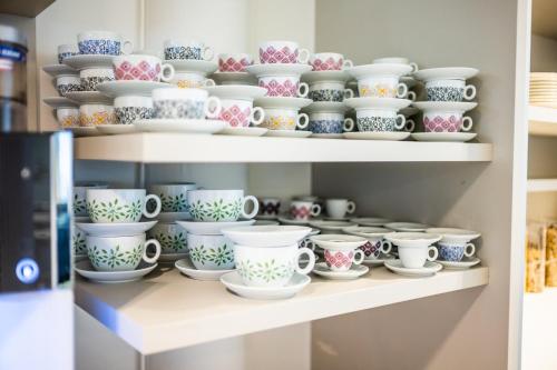 a bunch of cups and bowls on shelves at flexymotel Spielberg in Spielberg