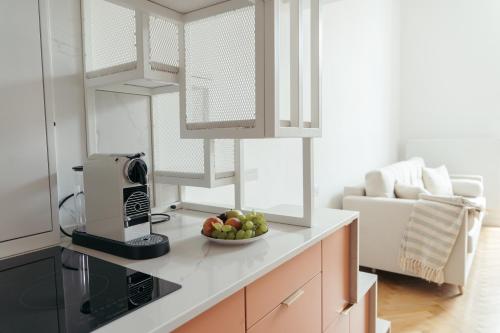 a kitchen with a bowl of fruit on a counter at L’appartement Korzó in Satu Mare