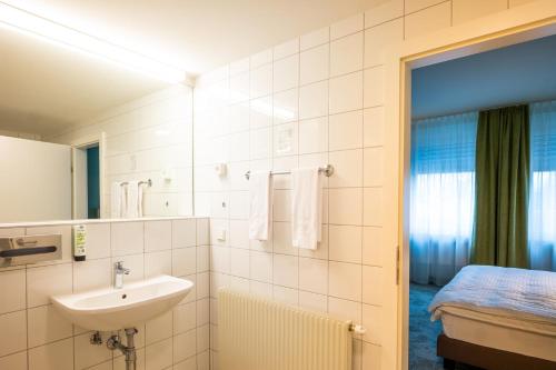 a bathroom with a sink and a mirror and a bed at flexymotel Spielberg in Spielberg