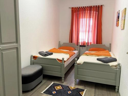 two twin beds in a small room with a window at Apartman Kraljica 2 in Kupres