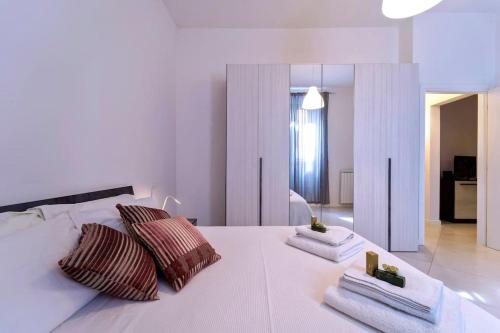 um quarto com uma cama branca com duas almofadas em Savonarola Comfy Flat em Florença