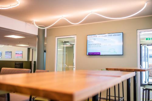 a meeting room with a table and a screen on the wall at flexymotel Spielberg in Spielberg