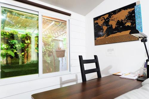 a table and a chair in a room with a window at Baan Wassana In The City Old Moat in Chiang Mai
