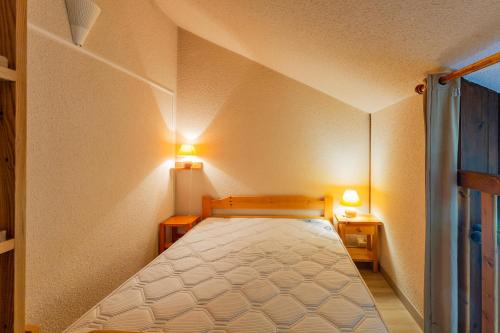 a bedroom with a bed with two lights on the wall at Aravis in Manigod