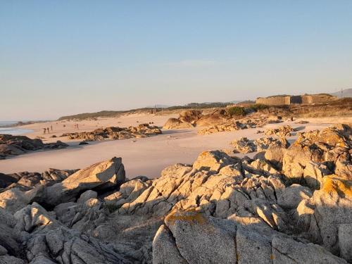 a beach with large rocks and a sandy beach at Casa da Varanda in Carreço