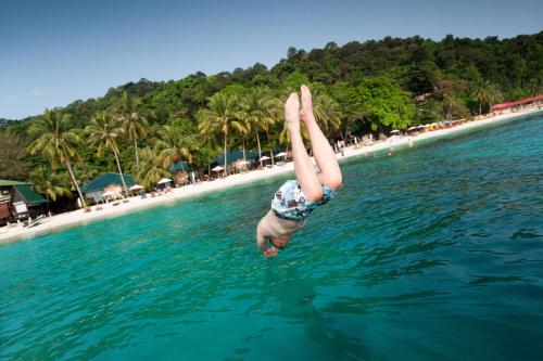 a man jumping in the air on top of a surfboard at Tuna Bay Island Resort in Perhentian Islands