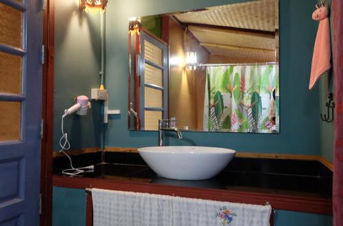 a bathroom with a sink and a large mirror at Baan Wassana In The City Old Moat in Chiang Mai