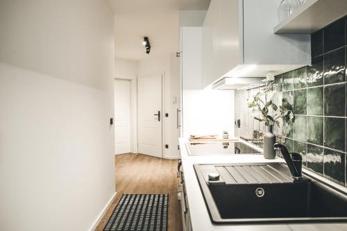 a white kitchen with a sink and a stove at Oskar Apartments in Neustift im Stubaital