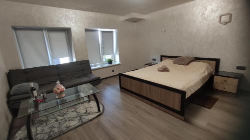 een woonkamer met een bed en een bank bij Мотель ''Ланівці'' in Lanivtsi