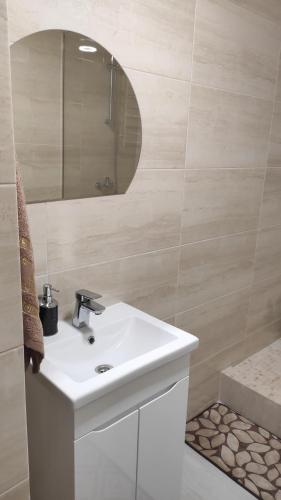 een badkamer met een witte wastafel en een spiegel bij Мотель ''Ланівці'' in Lanivtsi