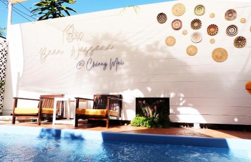 a wall with a fireplace next to a swimming pool at Baan Wassana In The City Old Moat in Chiang Mai