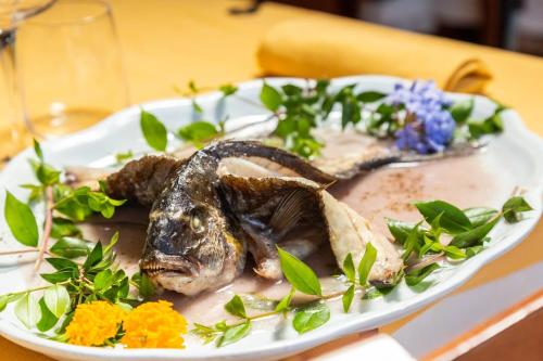 a plate of food with a fish on a table at Hotel L'Ulivo in Girasole