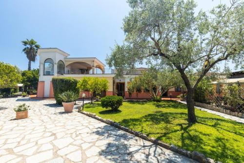 a house with a tree in the middle of a yard at Hotel L'Ulivo in Girasole