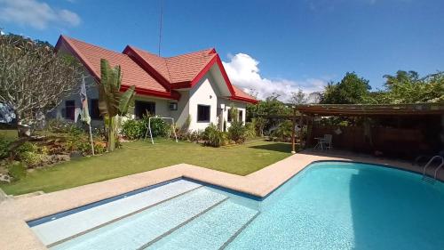 a house with a swimming pool in front of a house at Villa Shangri-La in Dumaguete