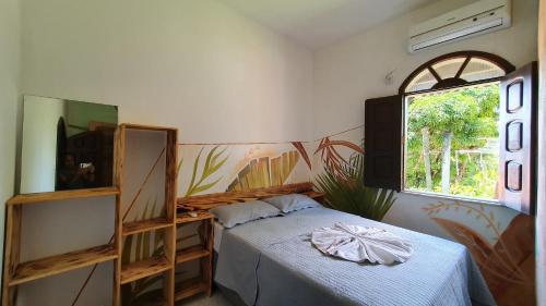 1 dormitorio con cama y ventana en Beleza Natural Pousada en Morro de São Paulo