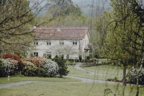 a large white house with a path in front of it at Amalurra Ecohotel & Retreat Center in Artzentales