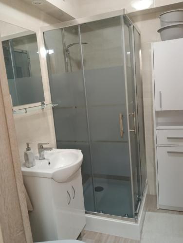 een badkamer met een douche, een toilet en een wastafel bij Apartament Osiedle Bajkowe in Ostrów Wielkopolski