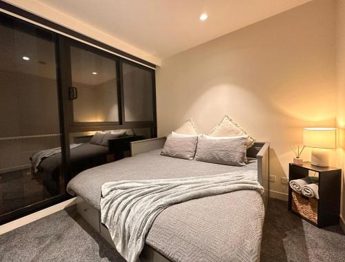 1 dormitorio con cama y ventana grande en Contemporary Comfort, en Melbourne