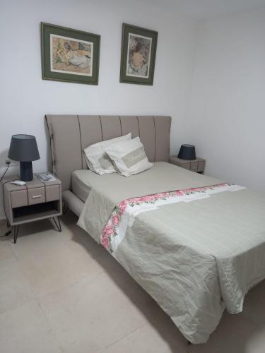 a bedroom with a large bed and a night stand at דירה קסומה בשכונת הגולף in Caesarea