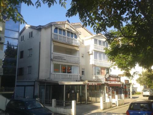 a tall white building on the corner of a street at Paladium Apartment in Budva