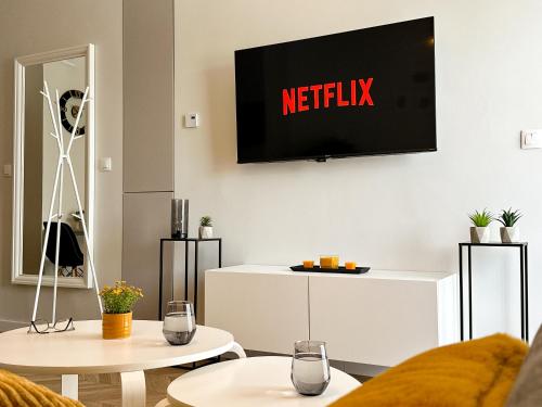 a living room with a television on a wall at Bursztyn Apartament in Zator