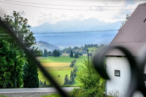 uma vista para um campo a partir de uma casa através de uma janela em Domki u Górala em Zakopane